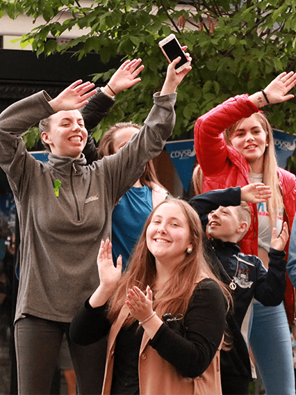 group of people waving arms