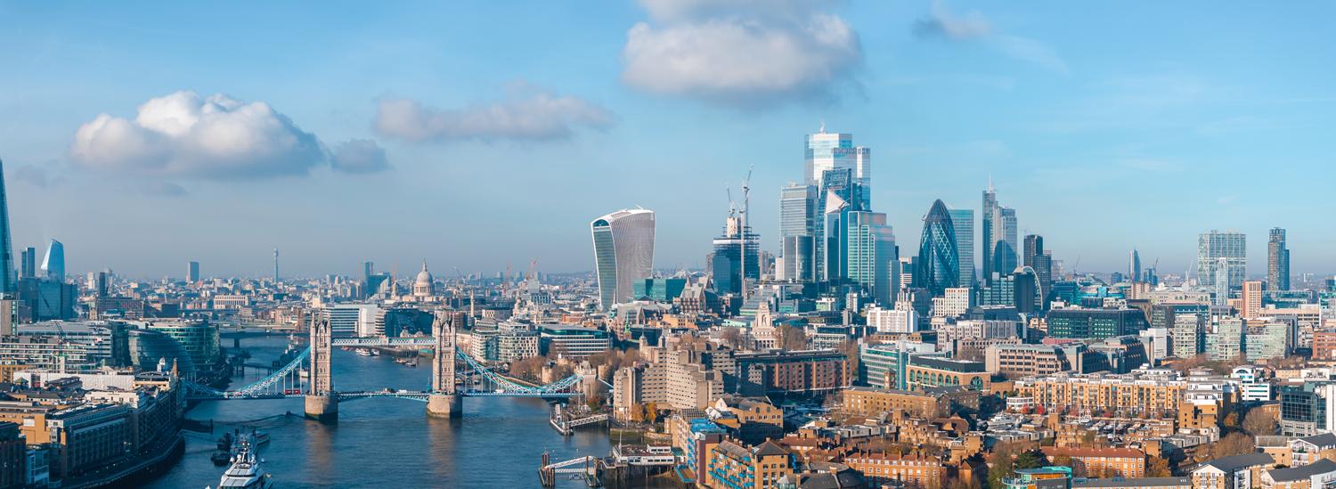 Panoramic view of London's skyline featuring Tower Bridge and modern skyscrapers.