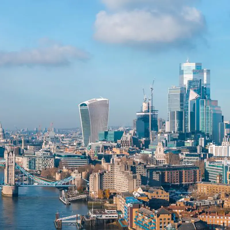 Panoramic view of London's skyline featuring Tower Bridge and modern skyscrapers.