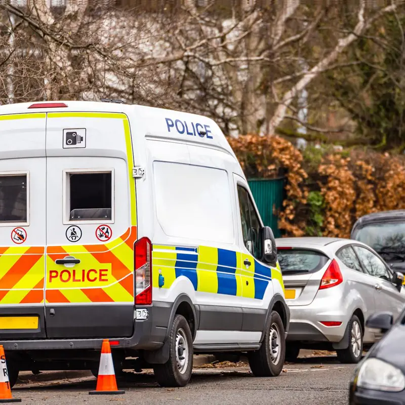 Police van parked on a street with traffic cones placed nearby.