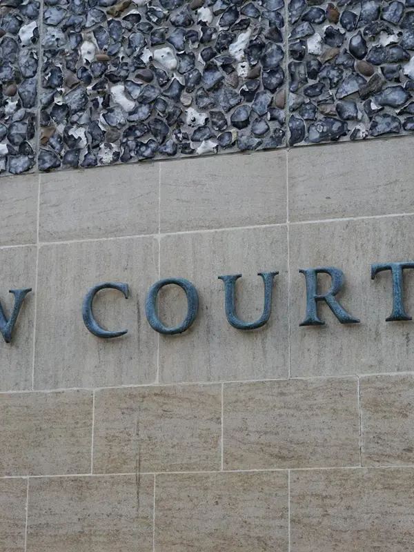 Stone wall with 'LAW COURTS' engraved, marking a courthouse entrance.