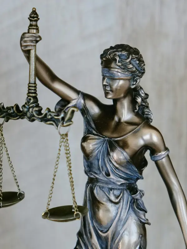 Blindfolded Lady Justice statue holding scales, symbolising law and fairness.