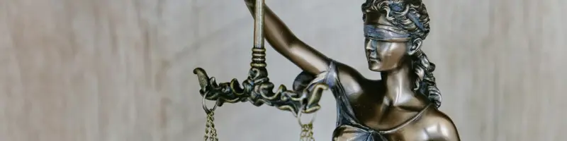 Blindfolded Lady Justice statue holding scales, symbolising law and fairness.