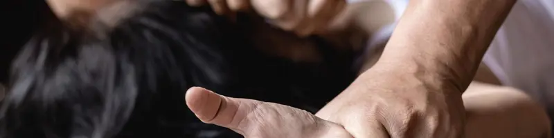 Depiction of physical restraint, showing a close-up of hands held down.